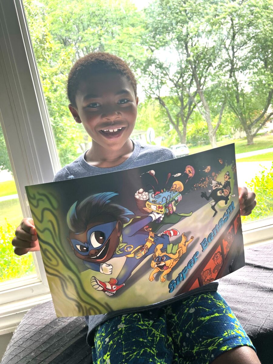 Photo of a child holding a poster of the superhero self they created and was designed by an artist.