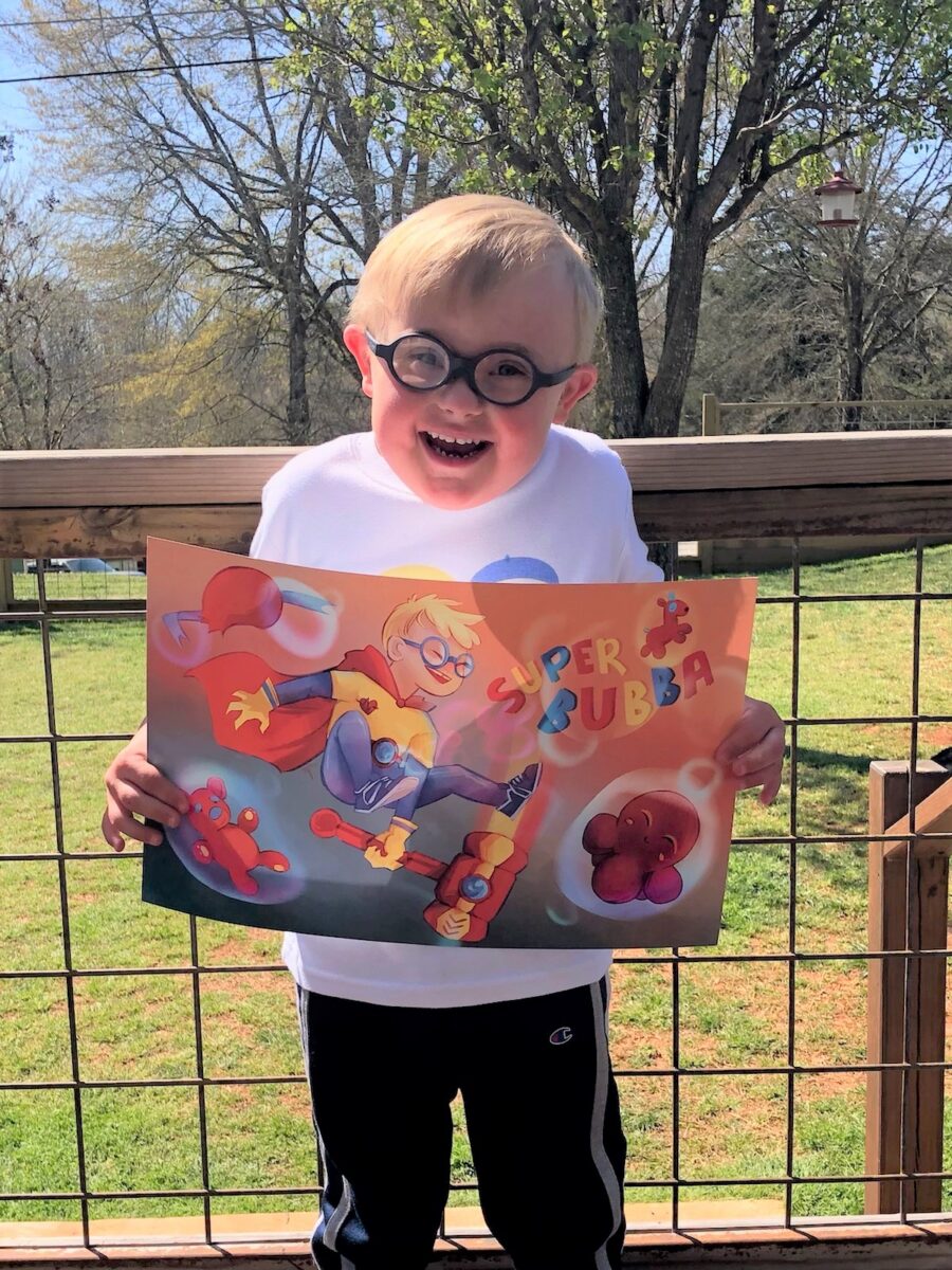 Photo of a child holding a poster of the superhero self they created and was designed by an artist.