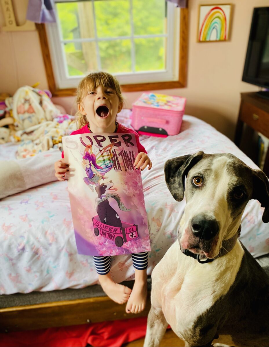 Photo of a child holding a poster of the superhero self they created and was designed by an artist.